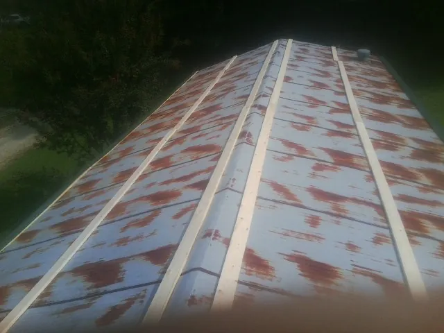 Rusted metal roof panels with new wood purlins before replacement — Storm Damage Roof Repair in Titusville by Roofing Brothers