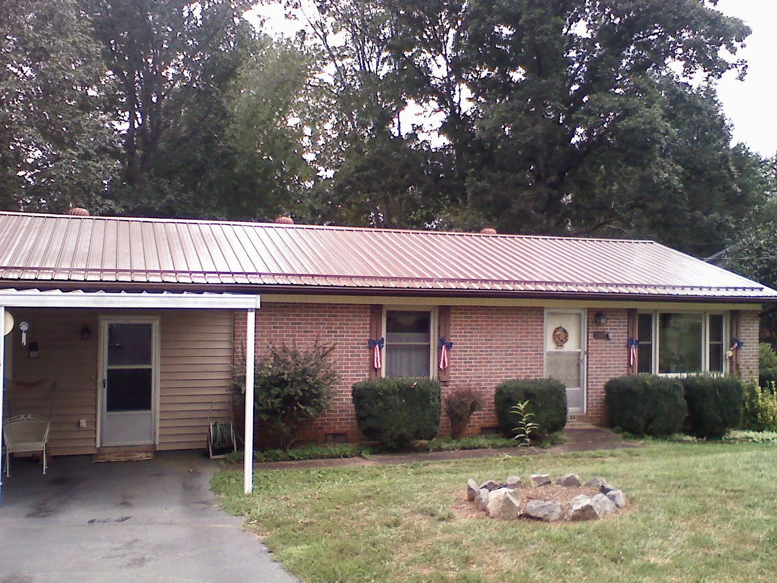 Bronze metal roof and carport on a brick ranch home — Roof Repair work by our crew in Titusville
